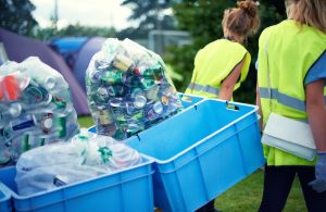 Team of rubbish cleaners removing cans in recycling boxes