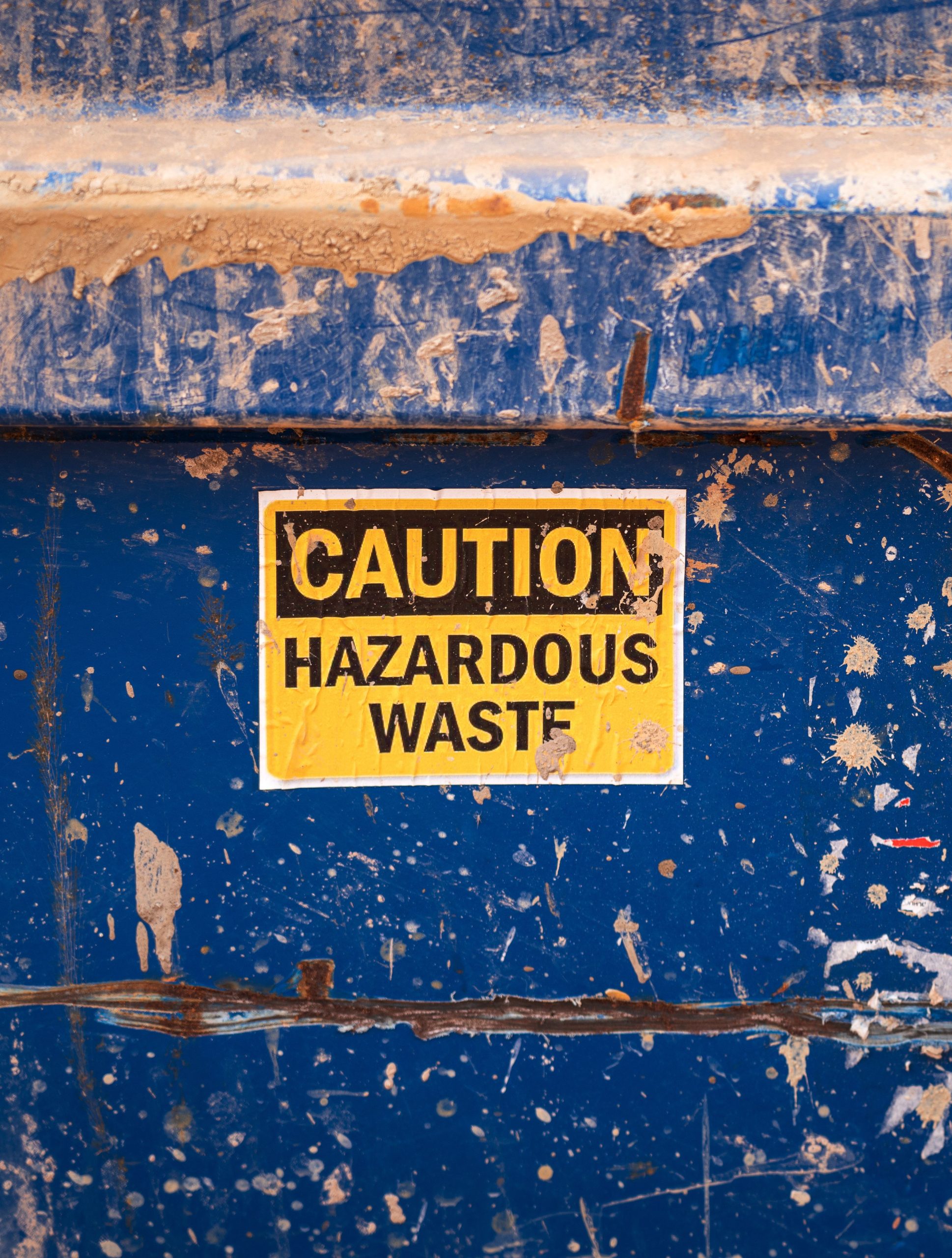 Hazardous waste caution label on storage bin